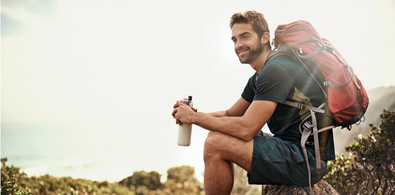 A man sitting on a rock while out hiking