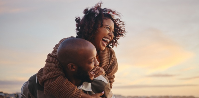 A man giving a woman a piggy back enjoying the outdoors.]