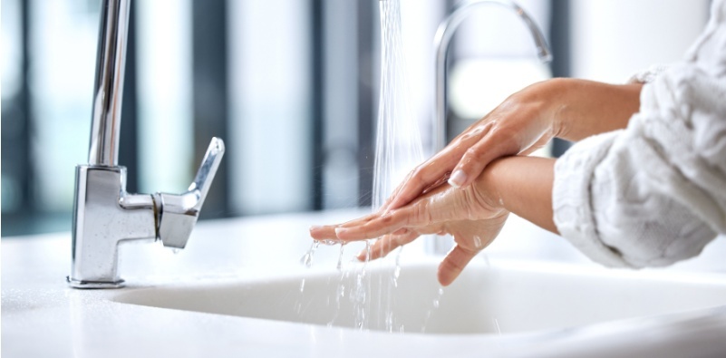 A woman washing her hands at the sink