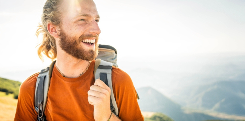 A man out hiking on a nice day, wearing contact lenses.