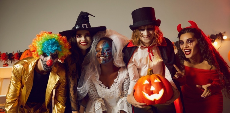 Happy young people dressed up as different spooky characters for Halloween.