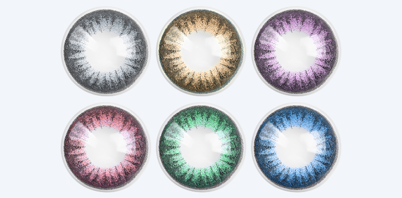 A range of different coloured contact lenses isolated on a light grey background.]