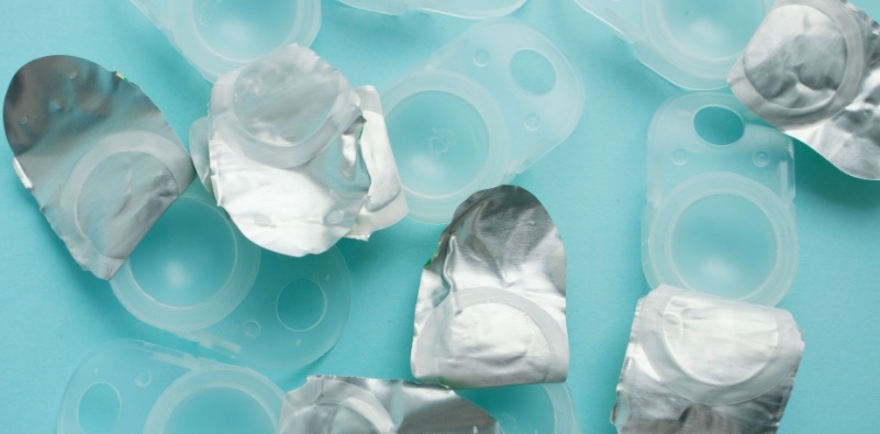 Open contact lens blister packs on a blue background