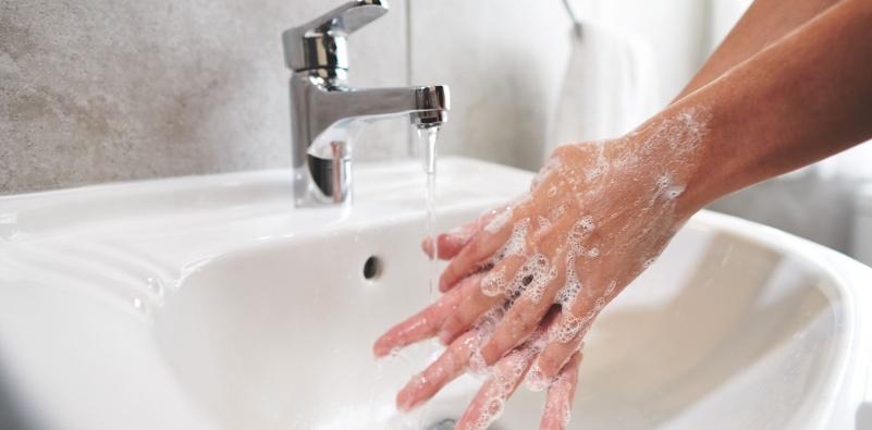 A person washing their hands in the sink