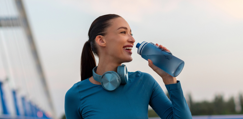Active woman drinking water after exercise while wearing contact lenses